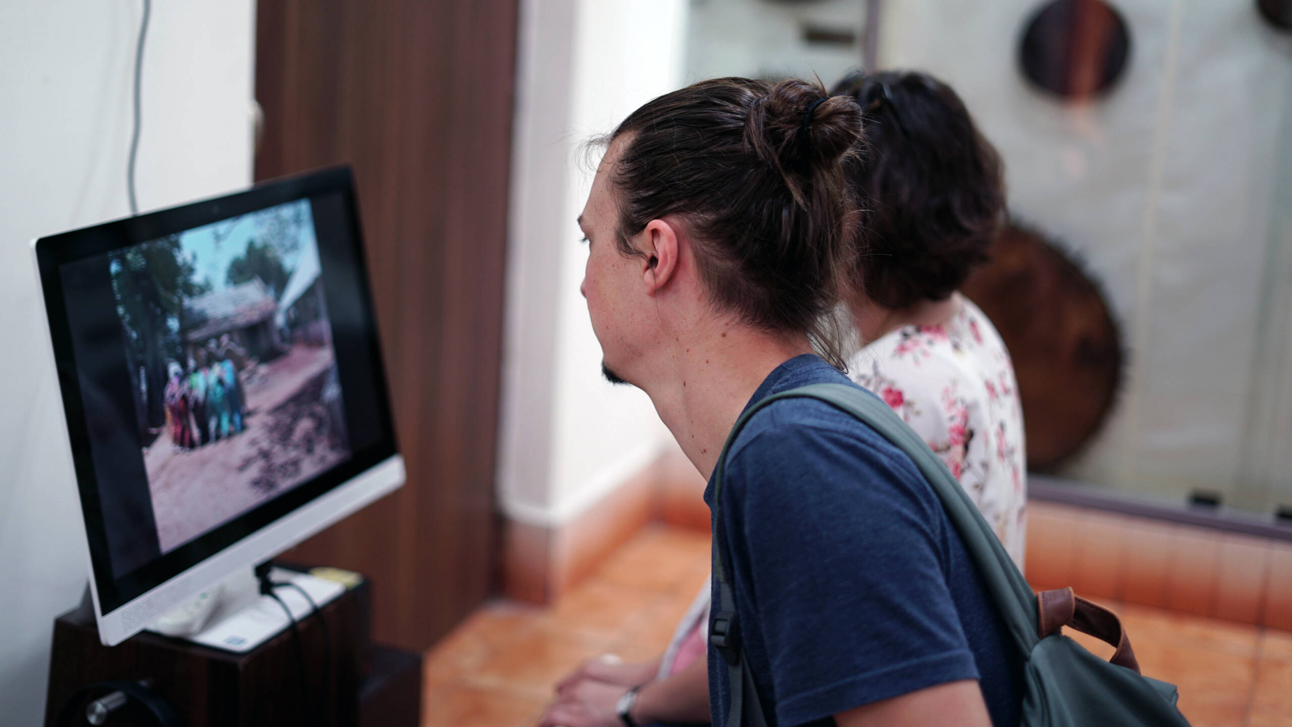 Two foreign visitors interacting with the touch screen kiosk