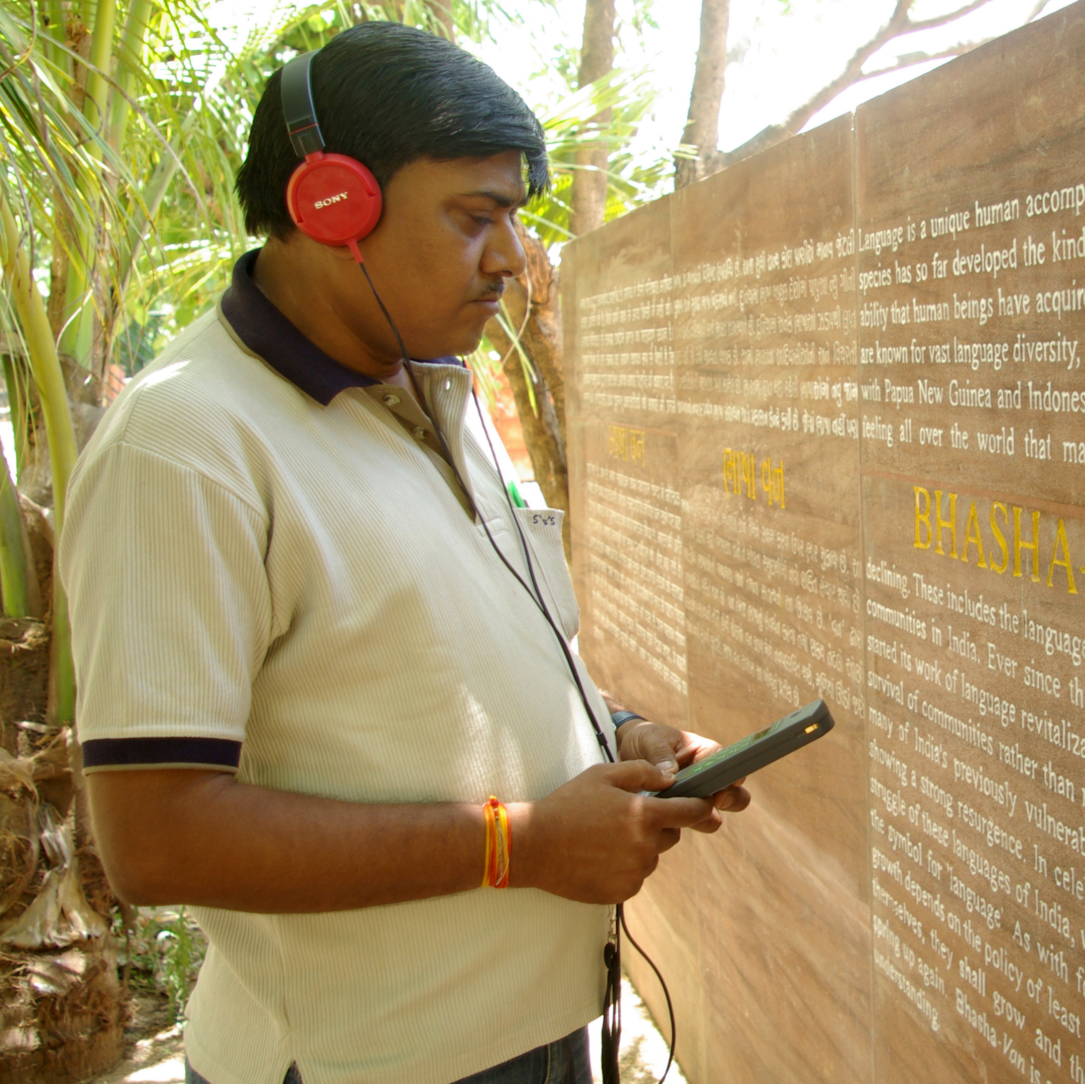 A visitor listening an audio tour at Bhasha Van