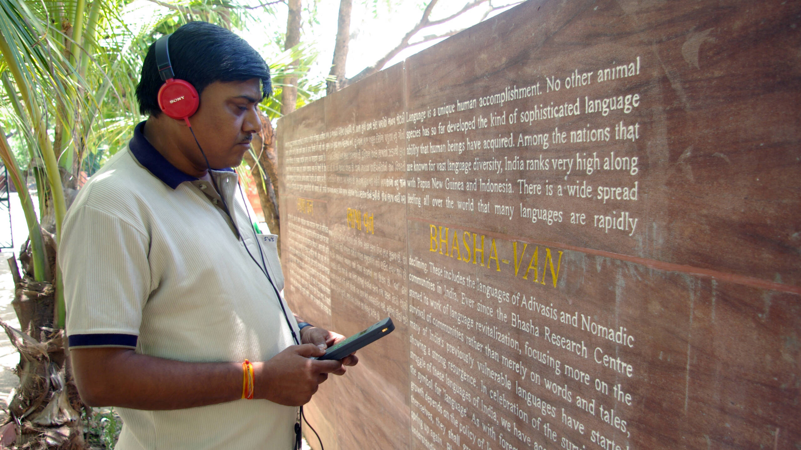 A visitor with audio guides at Bhasha Van